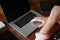 Man use laptop sitting at wooden desk with hand against his mouth