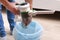 A man uses a bagless vertical cordless vacuum cleaner to clean floor