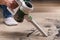 A man uses a bagless vertical cordless vacuum cleaner to clean floor