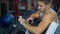 Man uses fitness tracker and synchronization with mobile phone in the gym