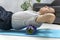 Man uses foam roller massager for relaxation and back pain. Workout at home. Man doing fascia exercise on the floor. Myofascial