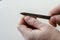 A man uses a nail file to trim his nails on his hand