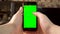 The man uses the phone. Hand makes a finger click on the smartphone with a green screen. Chroma key.