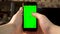 The man uses the phone. Hand makes swipe up on smartphone with green screen. Chroma key.