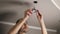 A man uses pliers while repairing a ceiling LED light fixture