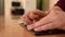 A man uses a special stencil and stylus to write a letter in braille.