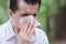 Man uses tissue paper sneezing due to having pollen allergy