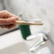 Man using a bamboo toothbrush in the bathroom