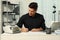 Man using banknote counter at white table indoors