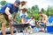 Man using bellows for preparing food in barbecue grill with friends on pier