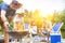 Man using bellows for preparing food in barbecue grill with friends on pier