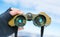 Man using binoculars on snow covered mountain