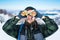 Man using binoculars on snow covered mountain