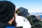 Man using binoculars on snow covered mountain