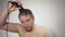 Man using clippers to shave head on white background, shot close-up