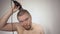 Man using clippers to shave head on white background, shot close-up