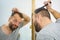 Man using comb in bathroom