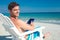 Man using digital tablet on deck chair at the beach