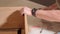 A man is using an electric drill to drive a screw into a cabinet. Furniture assembly.