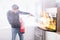 Man Using Fire Extinguisher To Stop Fire Coming From Oven