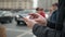 Man using his mobile phone outdoor, close up, man walking with cell phone on city street people and cars background