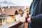 Man using his smart watch on the balcony and drinking coffee with an amazing view on the mountains and roofs of houses