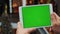 Man using horizontal tablet with green screen. Close-up shot of man`s hands with tablet. Chroma key. Close up