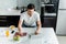 Man using laptop while working with charts on papers near cereals and apples on kitchen table