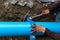 Man using a large wrench on water pipes. Construction site with new Water Pipes in the ground. Sewer pipes to repair or restore in