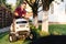 man using lawn tractor and cutting grass in garden during weekend time