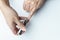 Man using nail clipper clipping her fingernails. white background