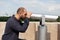 Man using panoramic binoculars telescope looking at metropolitan city
