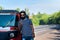 Man using phone standing by the tuk tuk taxi