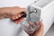 Man using pliers while preparing heating radiator for winter season, closeup