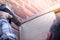 Man Using a Power Drill building a house porch at home in a sunny day