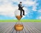 Man using smart pad sitting on sandglass