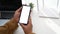 Man using smart phone and sitting in front of wireless router at home office.