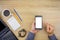 Man using smartphone with office work essential tools items on o