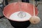 Man using a special ladle and copper cauldron containing milk turning into cheese