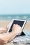 Man using a tablet on the beach