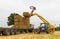 Man using a telehandler to load bales of straw onto a tractor trailer. UK