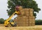 Man using a telehandler to move bales of straw. UK