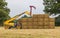 Man using a telehandler to move bales of straw. UK