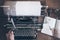 Man using vintage manual typewriter on rustic wooden table with motion blur due to carriage return