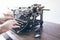 Man using vintage manual typewriter on rustic wooden table with motion blur due to carriage return