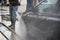 Man Using Water Pressure Machine to Wash a Car