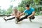 a man and a veiled girl in sportswear perform leg stretches before workout