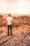 Man at view point looking to the bush savannah of Serengeti at sunset, Tanzania - Safari in Africa