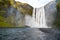 Man view Skogafoss Waterfall in Iceland