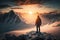 man, with view of the sun setting behind the mountain range, standing on snowy summit